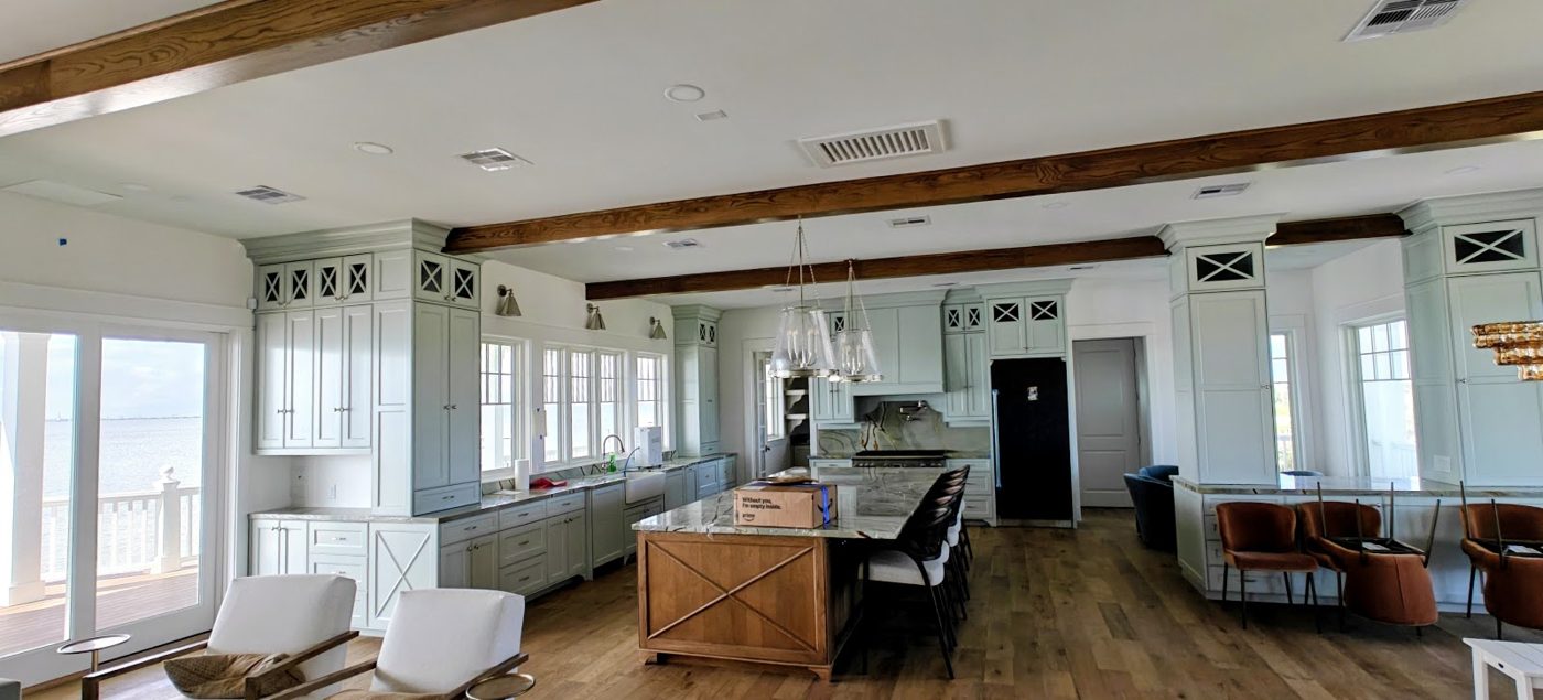 Open kitchen with painted cabinets and beamed ceiling