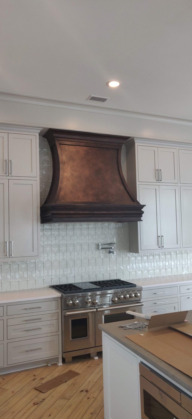 Painted kitchen cabinets with a copper range hood